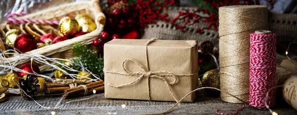 Gifts in craft paper and jute rope for Christmas on a wooden table.