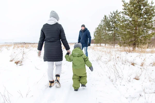 冬天步行穿过家庭公园.妈妈和宝宝到爸爸手里去. — 图库照片