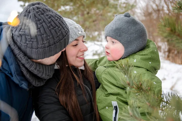 一个快乐的家庭，冬天在公园里带着一个小孩。母亲把婴儿抱在怀里. — 图库照片