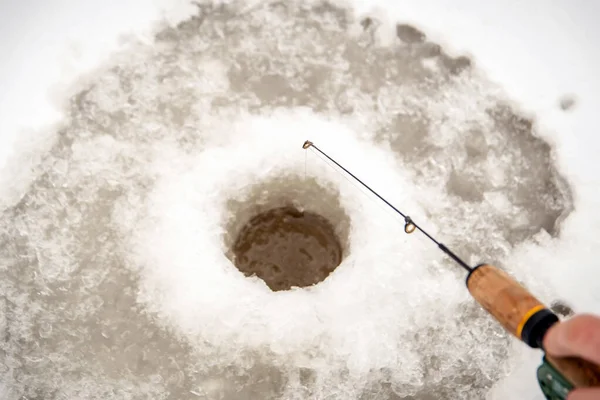 Winter fish. A hole in the ice for fishing and fishing rod