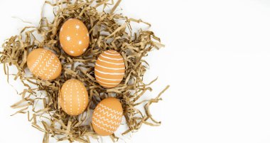 Beyaz arka planda kağıt işçiliği çimleri üzerinde minimum beyaz desenli doğal renk yumurtaları.