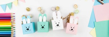 Renkli kağıtlardan Paskalya için çocuklarla el işi. Yumurta şeklinde tatlı olarak tavşanları kutular. Düz yatıyordu