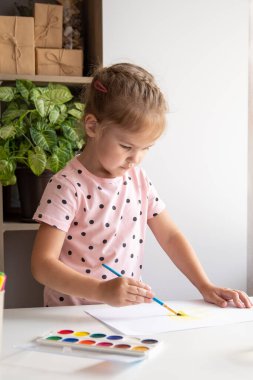 Evde resim yapan küçük bir kız. Yaratıcılık kavramı