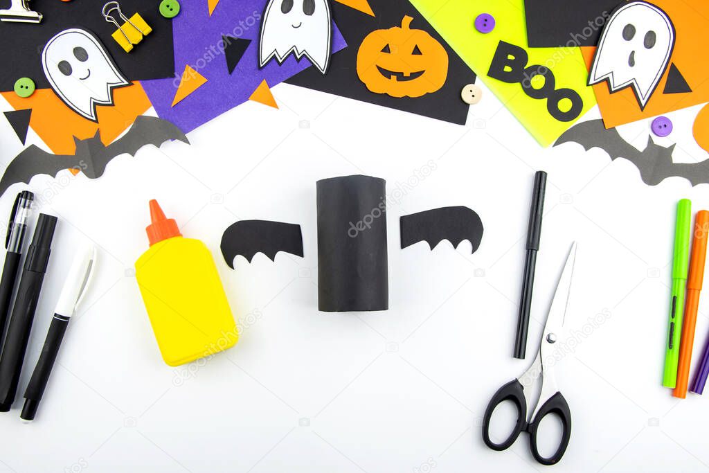 Craft with a child for Halloween from rolls of toilet paper and black paper bat. Step-by-step instruction.