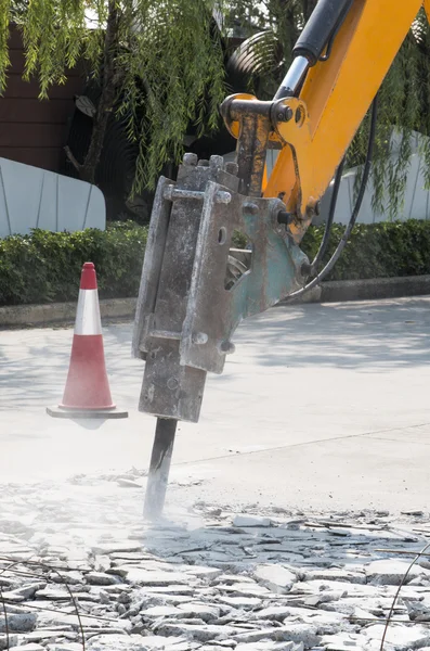 Excavadora rompiendo y perforando el camino de hormigón para la reparación Imágenes De Stock Sin Royalties Gratis