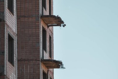Çok katlı terk edilmiş Sovyet binası cephesi çökmüş balkon silueti gökyüzünde. Birky, Ukrayna 'da bitmemiş nükleer bilim adamları şehri.