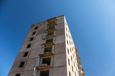 Yüksek çoklu katlı terk edilmiş Sovyet binası cephesi parlak mavi gökyüzünde. Yıpranmış konutlar, Birky, Ukrayna 'da bitmemiş nükleer bilim adamları şehri.