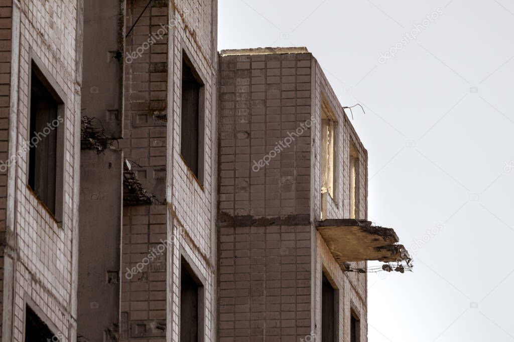 High multistorey abandoned soviet building facade with crashed balconies silhouette. Weathered housing estate, unfinished city of nuclear scientists in Birky, Ukraine
