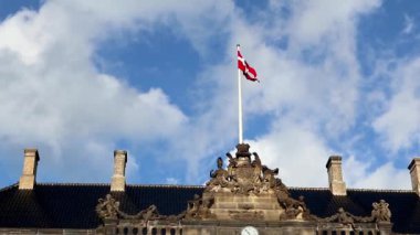 Kopenhag, Danimarka 'daki Amalienborg Sarayı' nda bayrak direğinde dalgalanan kırmızı bayrak güzel mavi gökyüzü ve manzaralı bulutlar.