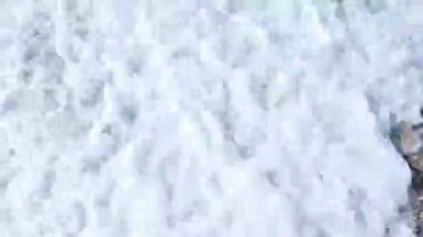 Beyaz dalgalar, Yunanistan 'ın Lefkada adasının sahilindeki çakıl taşı plajının en üst görüntüsünü oluşturuyor. İyon Denizi 'nin vahşi yaz doğası