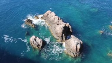 Dalgalar Yunanistan 'daki Lefkada adasının masmavi sularında kayalara çarpıyor. Yazın İyon Denizi 'ne vahşi doğa yolculuğu