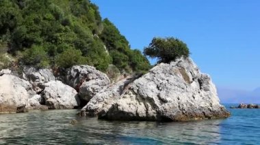 Yunanistan 'daki Lefkada adasının kayalık ve ormanlık sahillerindeki teknenin manzarası. İyon Denizi 'ne yaz tatili