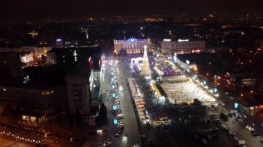 Gece Özgürlük Meydanı 'na (Kharkiv) yakın uçun. Yeni yıl tatilleri, Noel ağacı süslemeleri ve şehir merkezinde renkli aydınlatmalı buz pateni pisti.