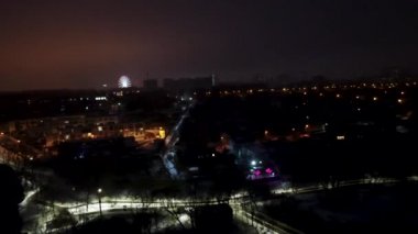 Kharkiv şehir merkezi İHA 4k soldan sağa Botanik bahçesi Sarzhyn Yar 'dan gece. Şehir ışıklarında hava manzarası ve arka planda dönme dolap