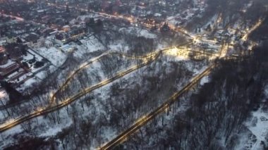 Kış akşamının üzerinde uçarak sisli bir günde Kharkiv şehir parkının bahçesini kilise ve oyun parklarıyla aydınlattı. Hava görüntüsü 4k arkaplanı