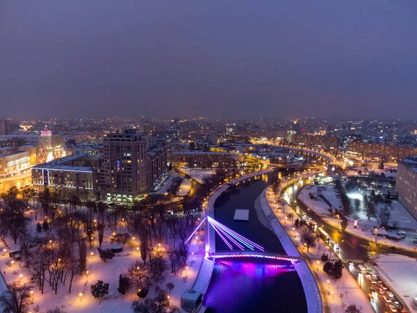 Köprü (Mist Zakokhanykh) Kharkiv şehir merkezindeki aydınlatılmış Skver Strilka nehrinde gece vakti ortaya çıkar. Kış akşamı renkli bir fotoğraf.