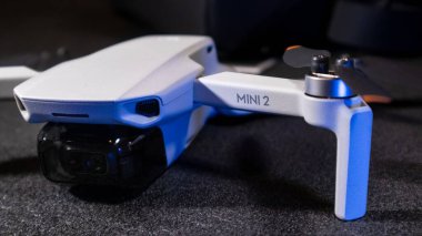 Kiev, Ukrayna - 02 Şubat 2021: Dji Mavic Mini 2 insansız hava aracı. Mavi ışıkta siyah arkaplanda yeni bir dörtlü helikopter aygıtı
