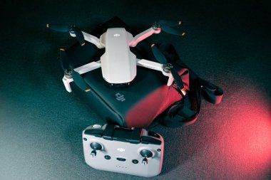 Kiev, Ukrayna - 02 Şubat 2021: Dji Mavic Mini 2 insansız hava aracı. Kırmızı ışıkta siyah arkaplanda uzaktan kumandalı siyah çanta üzerine yeni açılmış dörtgen.