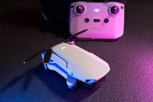 Kiev, Ukrayna - 02 Şubat 2021: Dji Mavic Mini 2 insansız hava aracı pervaneleri. Pembe ve mavi ışıkta siyah arkaplan üzerinde uzaktan kumandalı yeni kuadkopter
