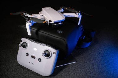Kiev, Ukrayna - 02 Şubat 2021: Dji Mavic Mini 2 insansız hava aracı. Siyah üzerine yeni kuadkopter kötü taşıyan uzaktan kumandalı mavi ışıkta siyah arkaplan