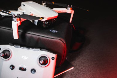 Kiev, Ukrayna - 02 Şubat 2021: Dji Mavic Mini 2 insansız hava aracı. Kırmızı ışıkta siyah arkaplanda uzaktan kumandalı siyah çanta üzerine yeni açılmış dörtgen.