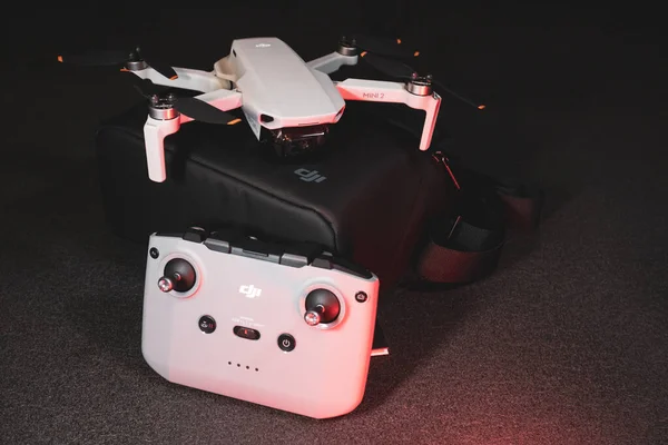 Kiev, Ukrayna - 02 Şubat 2021: Dji Mavic Mini 2 insansız hava aracı. Kırmızı ışıkta siyah arkaplanda uzaktan kumandalı siyah çanta üzerine yeni açılmış dörtgen.