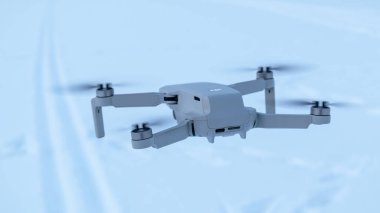 Kharkiv, Ukrayna - 21 Şubat 2021: Dji Maviç Mini 2 yakın planda uçan İHA. Beyaz kar arka planında yeni bir dörtlü helikopter cihazı. Arka plan, ileri uç.