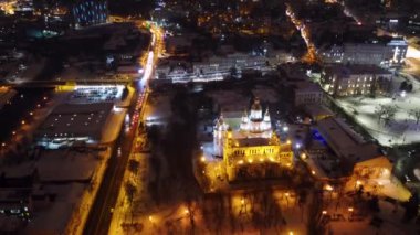 Kış gecesi ışıkları şehir merkezinin hava manzarasını aydınlatıyor. Ukrayna 'nın Kharkiv kentindeki Svyato-Pokrovsky Manastırı ve Independence Meydanı' nın yakınlarına uç.
