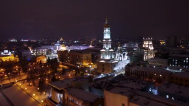 Kış gecesi ışıkları şehrin havadan görüntüsünü soldan aydınlatıyor. Kutsal Annunciation Katedrali, Dormition Katedrali, Serhiivskyi Meydan, Lopan nehri Kharkiv, Ukrayna