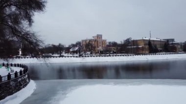 Lopan ve Kharkiv nehirlerinin su yüzeyinden Pedestrian Köprüsü 'ne (Mist Zakokhanykh) doğru alçaktan uç. Kış karlı hava şehir merkezi