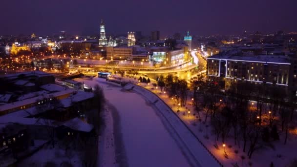 冬夜的夜晚 城市空中的镜头闪烁着灯光 繁忙的汽车 交通繁忙的街道和结冰的雪河 乌克兰哈尔科夫Serhiivskyi Maidan Dormition大教堂Skver Strilka — 图库视频影像