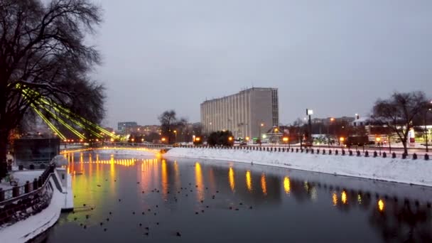 飞向Skver Strilka河对面的人行天桥 Mist Zakokhanykh 在哈尔科夫市中心 黄色的灯光照射在水面上 有灯光反射和鸭子 冬季空中飞行 — 图库视频影像