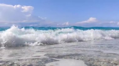 Yunanistan 'ın Lefkada adasının kıyısında, gök mavisi berrak ve berrak sularıyla çakıl taşlı plajda beyaz dalgalar var. Yaz vahşi doğa seyahati İyon Denizi 'ne