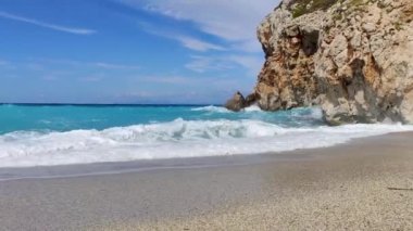 Yunanistan 'ın Lefkada adasının sahilindeki kayalık kayalıklara vuran gök mavisi parlak ve kuvvetli dalgalar. Yazın İyon Denizi 'ne vahşi doğa yolculuğu