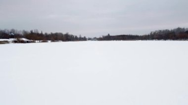Lugopark dinlenme alanındaki barajlı Kharkiv 'in kış manzarası. Karla kaplı beyaz, donmuş Lopan nehrinin üzerinden uç..