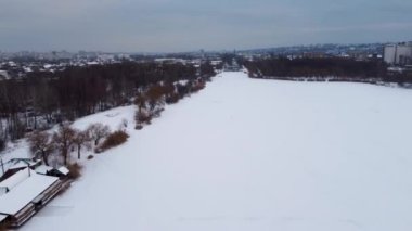 Lugopark dinlenme bölgesinden Kharkiv 'in kışın hava manzarası ve donmuş Lopan nehri karla kaplı. Hızlandırıcı nehrin üzerinden baraja uçar
