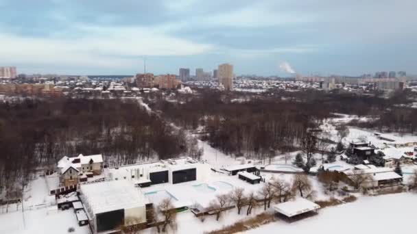 洛凡河上有冰冻室外游泳池娱乐区的卢格帕克到冬季有多层住宅的哈尔科夫市的空中左向右看 — 图库视频影像