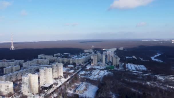 右側に左に空中ハリコフ市内中心部とパヴラブポール ソコルニキ地区を表示します 冬は電気通信タワーアンテナ付きの森の近くの複数階建ての建物 — ストック動画