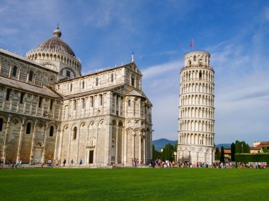 Eğik Pisa Kulesi (özenle süslenmiş 14. yüzyıl kulesi) ve Katedral di Pisa (mermer çizgili katedral) yaz yeşil çimenleri ve mavi gökyüzü üzerinde. İtalya 'yı gezmek, ünlü yerler