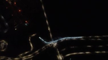 Yukarı uç ve gece üzerinde saat yönünün tersine dön aydınlanmış sokaklar ve yükseltilmiş metal köprü. Ukrayna 'nın Kharkiv kentindeki Botanik Bahçesi' nde hava manzarası