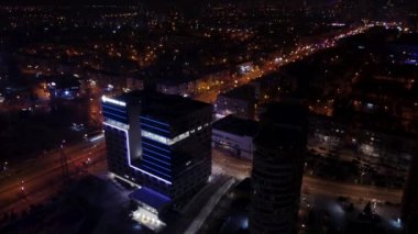 Kharkiv şehrinde aydınlatması olan çok katlı modern yüksek binanın havadan karanlık manzarası. Nauky Bulvarı 'ndaki Botanik Bahçesi (Sarzhyn Yar), sokak lambalı gece şehri.