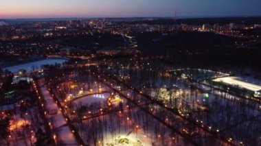 Kharkiv şehir merkezinde günbatımı renkleriyle, Gorky Central Park insansız hava aracı görüntüleri. Şehir ışıklarına, sokaklara ve eğlence merkezlerine hava manzarası