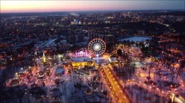 Kışları Kharkiv şehir merkezinde hava manzarası, Gorky Central Park 'ta soldan sağa dönme uçak. Şehir ışıkları, arka planı bulanık sokaklar