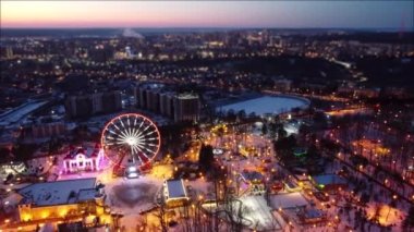 Aydınlatılmış dönme dolap ve çekimler için hava manzarası. Kışları Kharkiv şehir merkezinde Dronie (uç ve kaç) görüntüleri. Gün batımında eğlence Gorky Central Park. Şehir ışıkları gökyüzünde