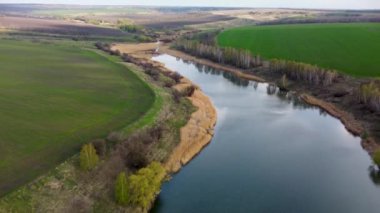 Etrafı genç yeşil yay tarlalarıyla çevrili manzaralı göle doğru uç. Kırsal kesimde güzel yansımalar var.