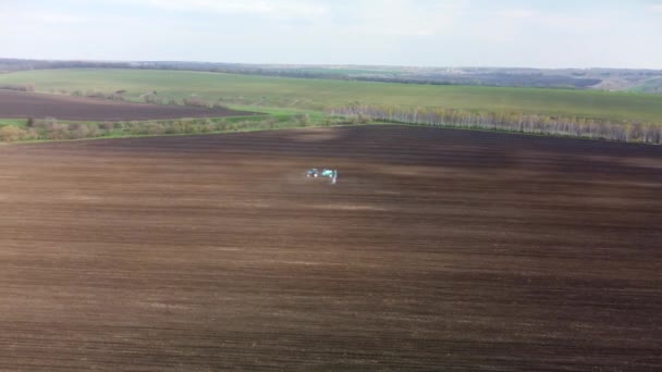 Seguimiento Escénico Aéreo Del Tractor Azul Con Largos Auges Rociando — Vídeos de Stock