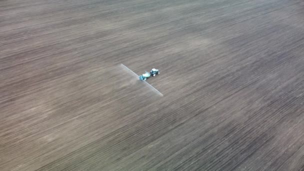 空中跟随蓝色拖拉机在耕地上喷洒种子 向右转 农业春季背景影片 — 图库视频影像