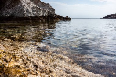 Kayalık kıyısı ve kristal berrak suyu olan vahşi Akdeniz. Atina yakınlarında Yunanistan 'ı gezmek. Yaz doğası manzaralı göl