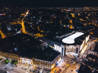 Kharkiv, Ukrayna - 21 Mayıs 2021: Nikolsky Alışveriş Merkezi açılış etkinliği. Gece ışıkları şehrin çatı manzarasını aydınlatıyordu. Ukrayna 'nın Kharkiv kentindeki Konstytutsii Meydanı yakınlarındaki şehir merkezi