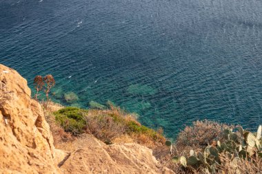 Akdeniz kıyısında turkuaz suyu olan kayalık bir kıyı. Atina yakınlarında Yunanistan 'ı gezmek. Yaz güneşli doğa manzarası